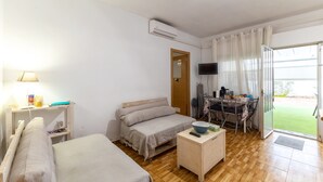 A room with two beds, a desk with a chair, a TV, and a door leading to a balcony. - Sol y Luna Countryside Home with Pool near Toledo and Puy du Fou (Manzaneque)