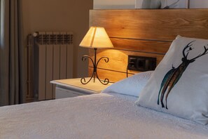 A neatly made bed with a white pillow featuring a deer design, a bedside lamp on a wooden nightstand, and a wooden headboard. - Country House 'El Racó D'Espunyes' with Mountain View, Private Pool and Wi-Fi (Odén)