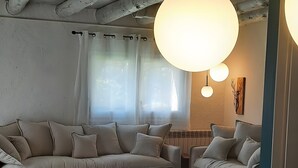 Een kamer met een houten eettafel, twee banken en een hanglamp.