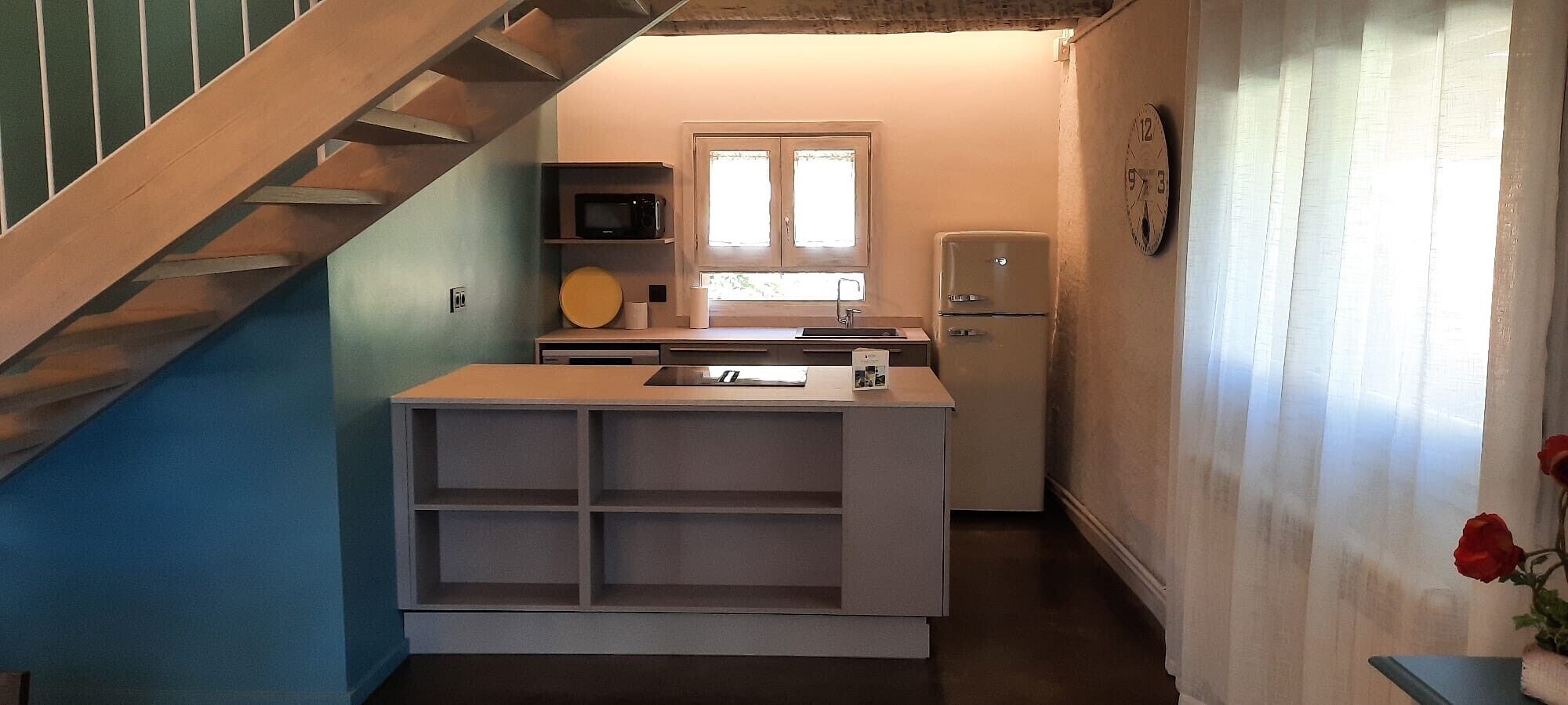 A compact kitchen with a built-in microwave, a sink, and a refrigerator.