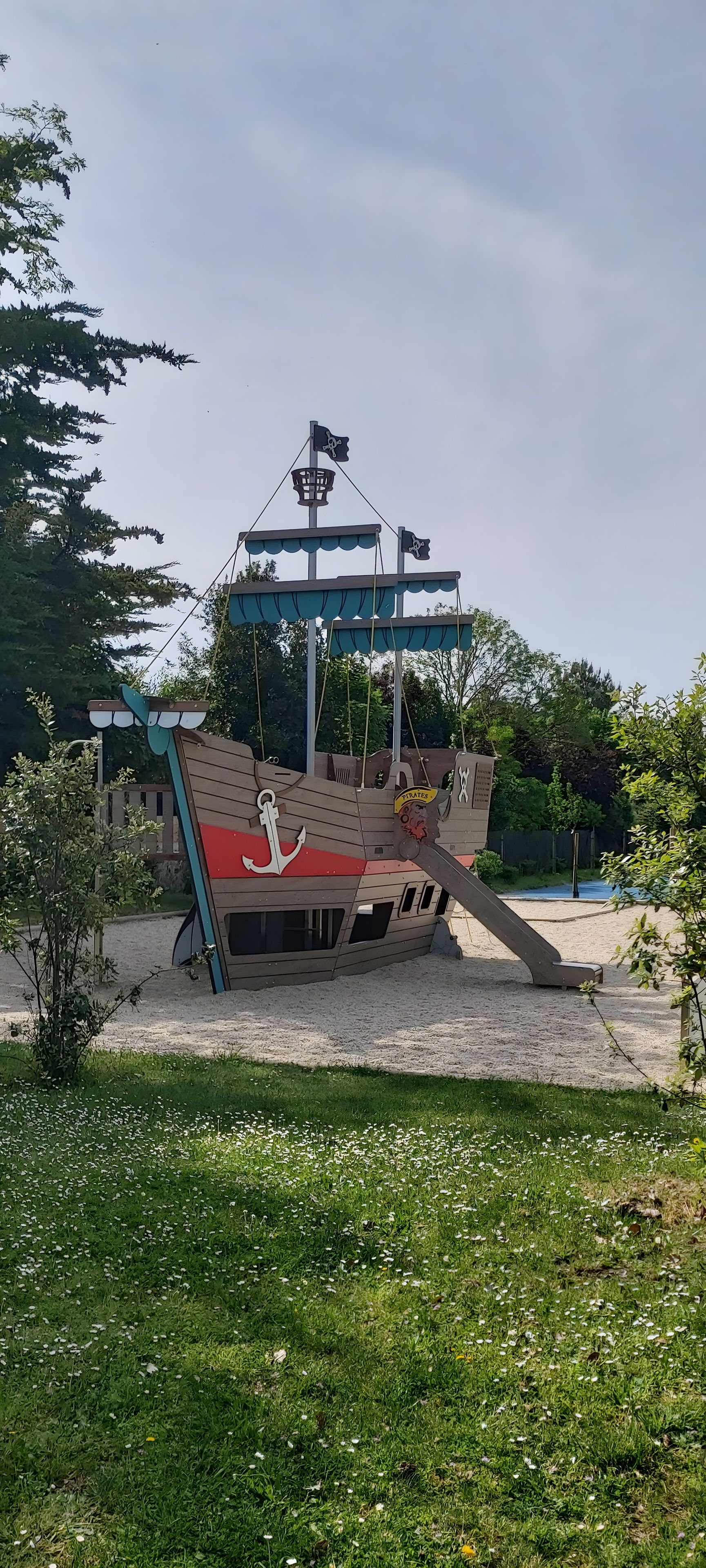 En lekställning med pirattema, utformad som ett skepp, och som inkluderar en flagga, ett ankare och en livboj.