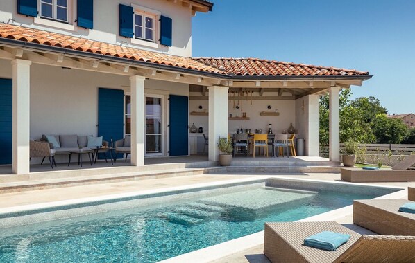 A villa with a swimming pool, outdoor seating, and a covered patio area. - Beautiful home in Maruzini with sauna (Maruzini)