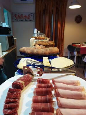 A cheese and meat platter with bread and a sign reading 'Welcome to our home!'