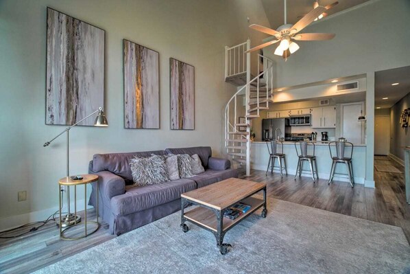 A modern living room with a sofa, coffee table, and artwork on the wall.