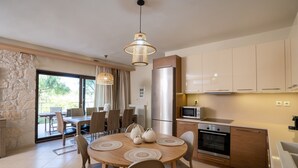 A modern kitchen with a refrigerator, oven, microwave, and wooden cabinets. - Holiday Home Timos Villa with Mountain View, Wi-Fi and Air Conditioning (Zakynthos)