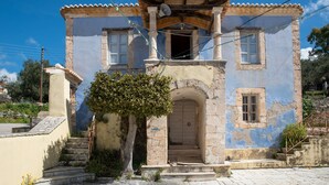 A two-story building with a tiled roof, a central doorway, and a small balcony. - Holiday Home Timos Villa with Mountain View, Wi-Fi and Air Conditioning (Zakynthos)