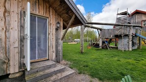 Una baita di legno con una porta scorrevole e un piccolo portico.