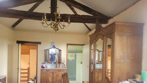 A bedroom with a bed, wooden wardrobe, and a mirror. - Holiday Home 'Pey Sud' with Mountain View, Private Terrace and Wi-Fi (Sistels)