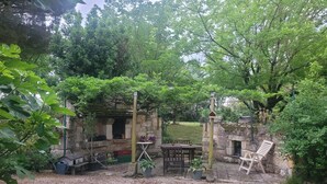 A rustic outdoor seating area with a stone wall, a wooden table, and a bench. - Apartment "Familha" with Mountain View, Private Terrace and Wi-Fi (Sistels)