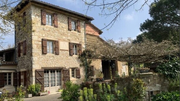 A stone building with wooden shutters, a covered porch, and a garden with various plants. - Apartment "Familha" with Mountain View, Private Terrace and Wi-Fi (Sistels)
