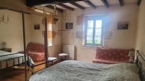 A bedroom with a four-poster bed, a wooden chair, a small table with a lamp, and a window with curtains. - Apartment "Familha" with Mountain View, Private Terrace and Wi-Fi (Sistels)