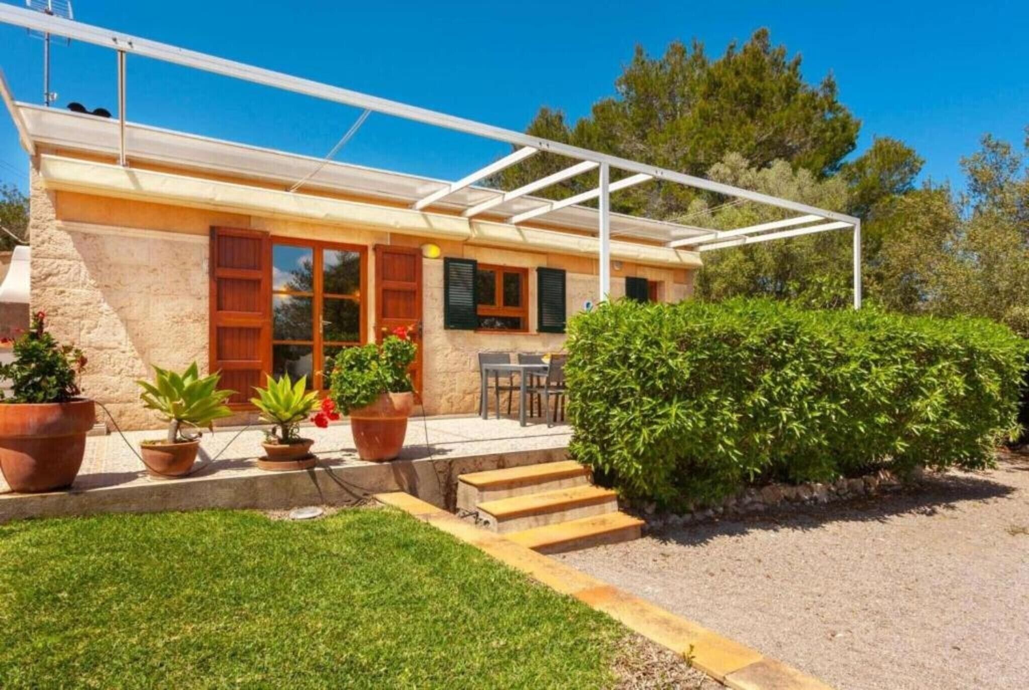 Een huis met een overdekte patio, stenen muren en bloempotten.