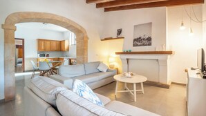 Una sala de estar moderna con un sofá, un comedor y una cocina al fondo.