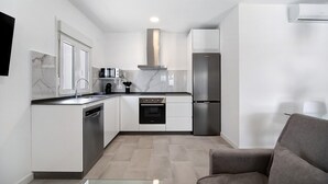 A modern kitchen with white cabinetry, a stainless steel oven, and a built-in dishwasher.