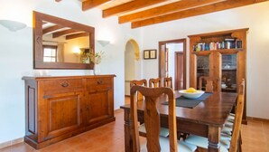 Un coin repas comprenant une table en bois, des chaises, un buffet et un miroir.