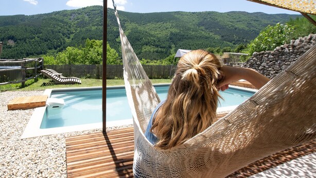 A hammock by a pool with a view of a forested mountain. - Apartment 'La Ferme De Chalas - Appart'chambre' with Shared Pool, Shared Terrace and Wi-Fi (Valgorge)