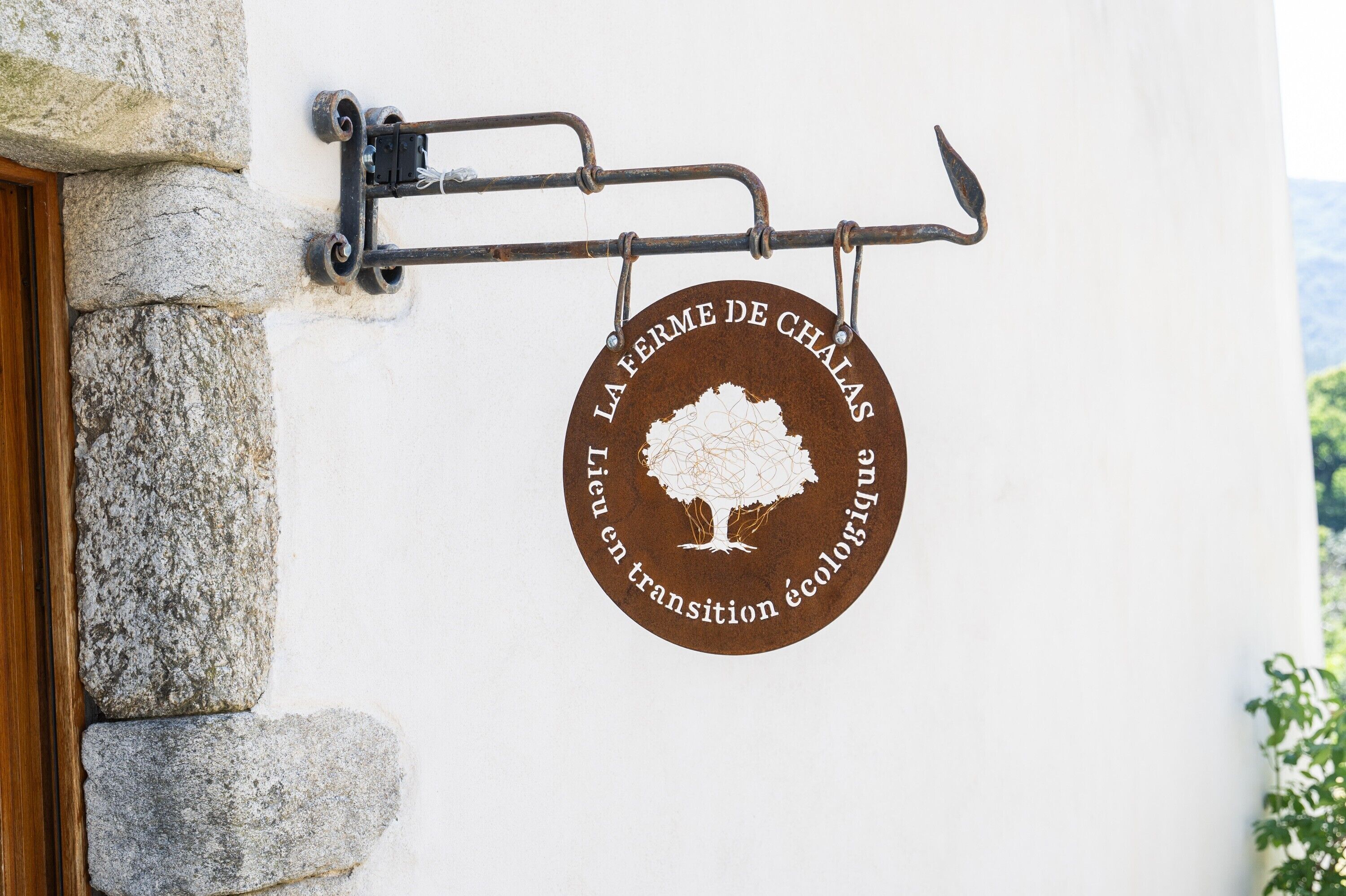 A circular sign with a tree and text on a wall.