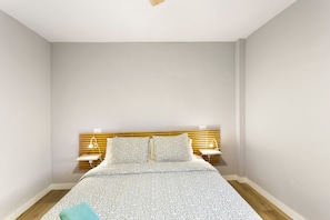 A bedroom with a bed, bedside tables, and a headboard.