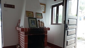 Ein Zimmer mit Kamin aus Backsteinen, Teppich und einer Tür mit Fenster.