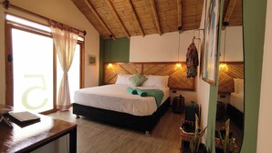 A room with a bed, a desk, and a window with curtains. - Hotel Boutique Puerto (Máncora)