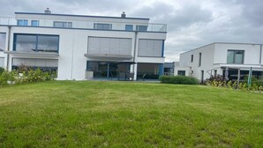 Ein modernes, zweistöckiges Gebäude mit großen Fenstern und einer flachen Dachkonstruktion.