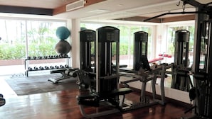 Una palestra con attrezzature per esercizi, una panca e un supporto per manubri.