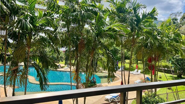 Una piscina circondata da palme con vista su un edificio sullo sfondo.