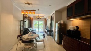 A modern kitchen with a dining area, featuring a refrigerator, stove, and a dining table with chairs.