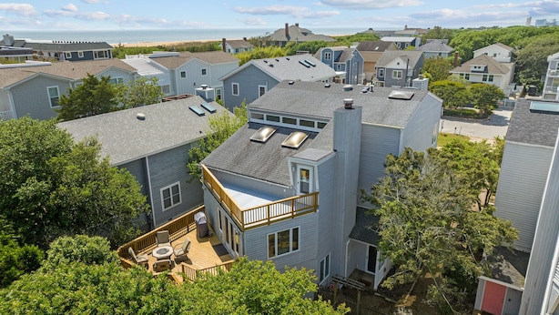 A residential area with houses featuring sloped roofs, a balcony, and a deck with outdoor furniture. - Enjoy your vacation at the Triple Wave Rider (Virginia Beach)