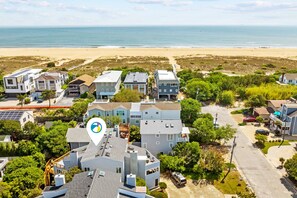 An aerial view of a residential area with houses, a beach, and a clear sky. - Enjoy your vacation at the Triple Wave Rider (Virginia Beach)