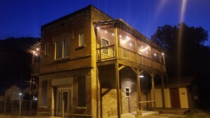 Un edificio de dos pisos con balcón y luces colgantes.