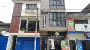 A two-story building with a sign for 'HOSPEDAL' on the ground floor and 'SPAÇO DO CABELO SALON & SPA' on the upper floor. - Gran Imperial Avenida (Tumbes)