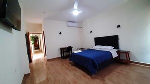 A bedroom with a bed, bedside tables, a TV, and a ceiling fan. - Gran Imperial Avenida (Tumbes)