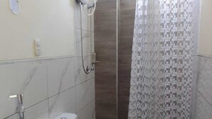 A bathroom with a white sink, toilet, and shower area. - Gran Imperial Avenida (Tumbes)