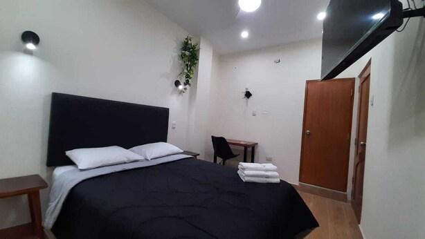 A bedroom with a bed, a desk, a chair, and a wardrobe. - Gran Imperial Avenida (Tumbes)