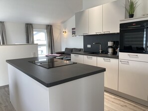 Una cocina moderna con una isla central, electrodomésticos integrados y un diseño minimalista.