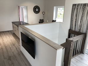 A modern kitchen with a central island, a built-in oven, and a window with curtains. - "meeresjuwel" Mairin - "mairin - Stern des Meeres" im Haus Meeresjuwel! (Dahme)