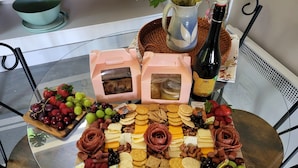 A table with a variety of cheeses, crackers, and fruits.