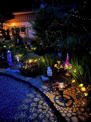 A garden with decorative lights, a pathway, and a small pond.