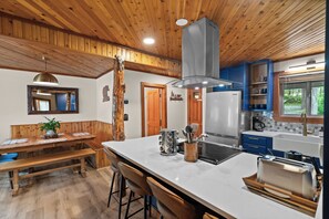 Enjoy cooking in this well-equipped kitchen with a central island, stove, and toaster.