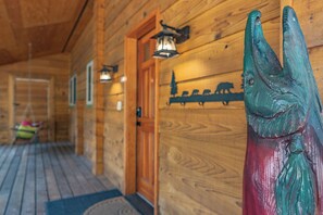 Enter a cozy cabin with a traditional wooden door, classic lighting, and a comfortable bench.