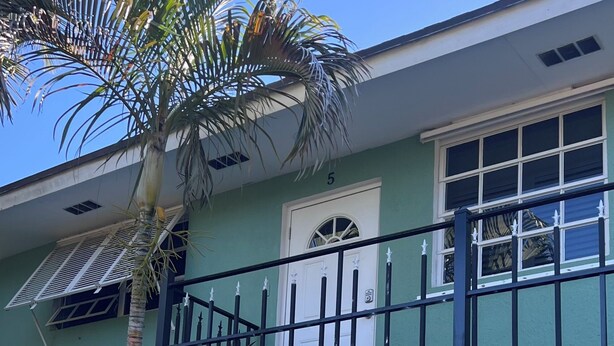 A two-story building with a balcony, a door, and windows. - Get away to Green Pastures #6 .10 min drive to Beach, Great for weekend getaways (Nassau)