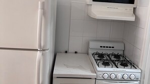 A compact kitchen with a white refrigerator, a stove, an oven, and a microwave. - Get away to Green Pastures #6 .10 min drive to Beach, Great for weekend getaways (Nassau)