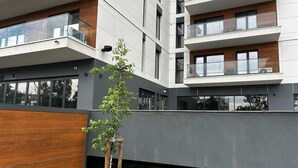 En modern byggnad med flera våningar, balkonger och stora fönster.
