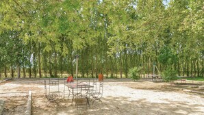 An outdoor area with a basketball court, a table with chairs, and a swing set. - 3 bedroom lovely apartment in Le Sambuc (Le Sambuc)