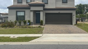 Une maison à deux étages avec un garage, portant le numéro 249, et une allée menant à la porte d’entrée.