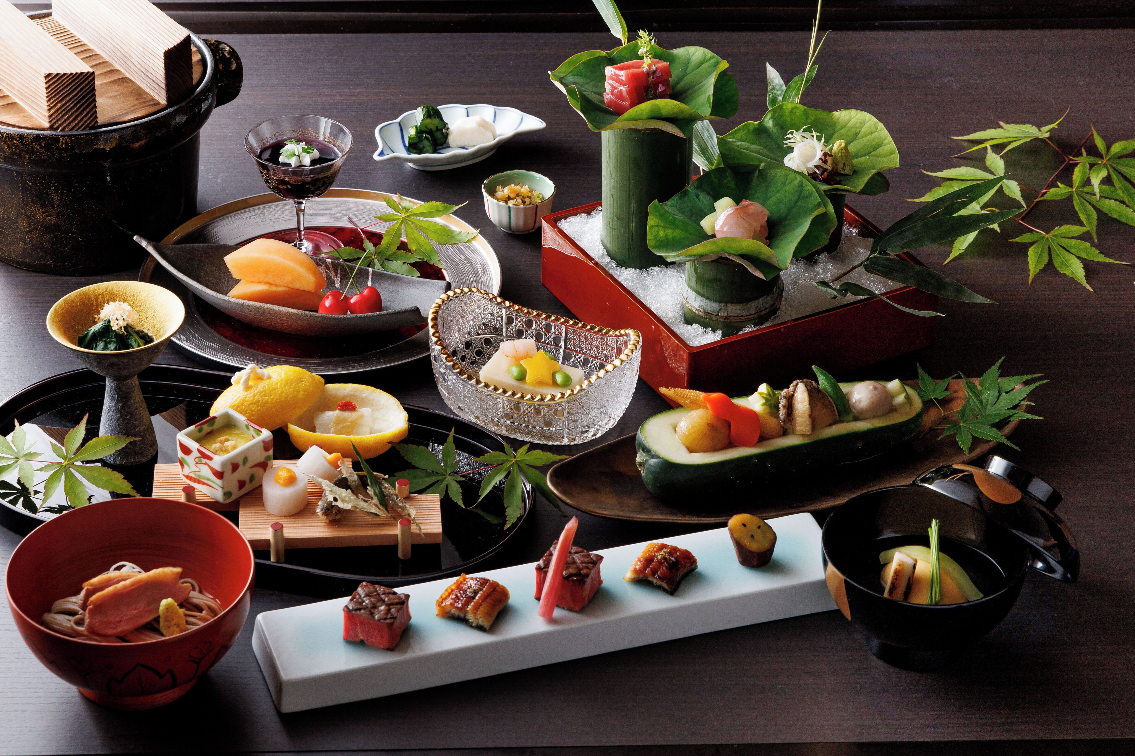 Diversos pratos e iguarias dispostos numa mesa, incluindo sushi, sashimi e outras especialidades.