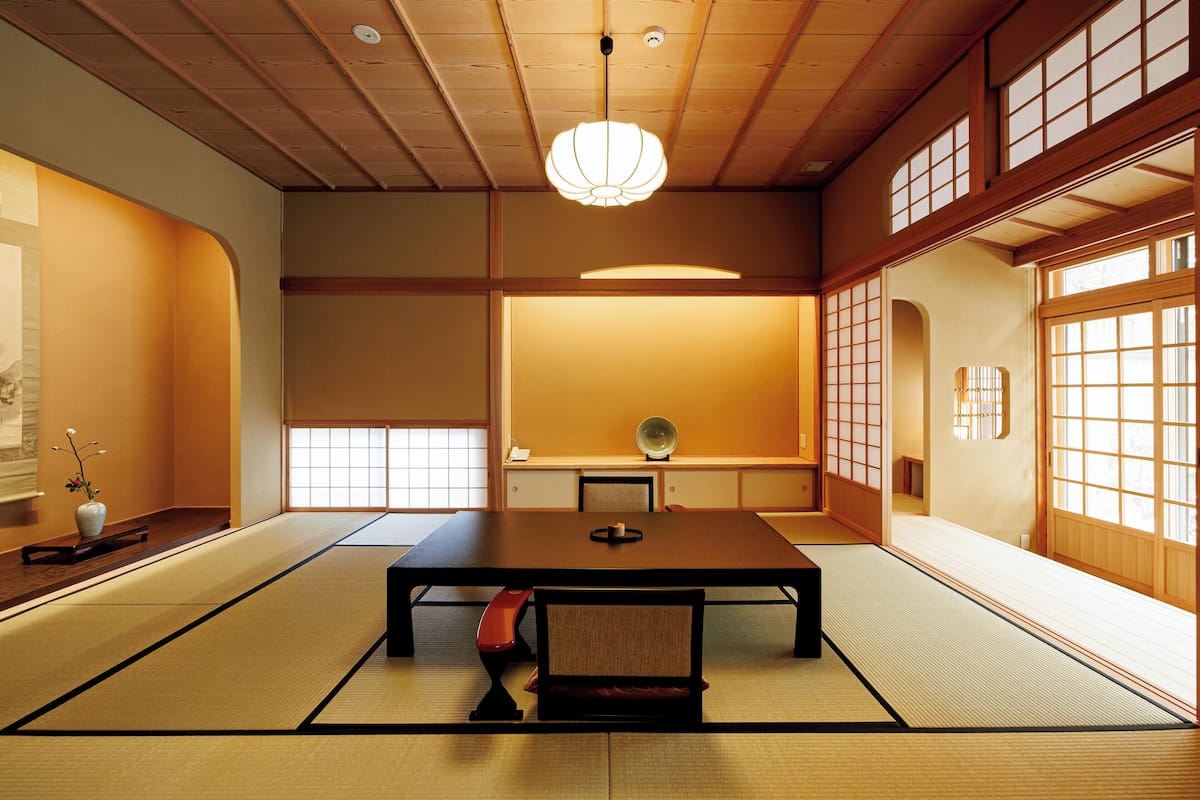 A traditional Japanese room with tatami flooring, a low table, and sliding doors.