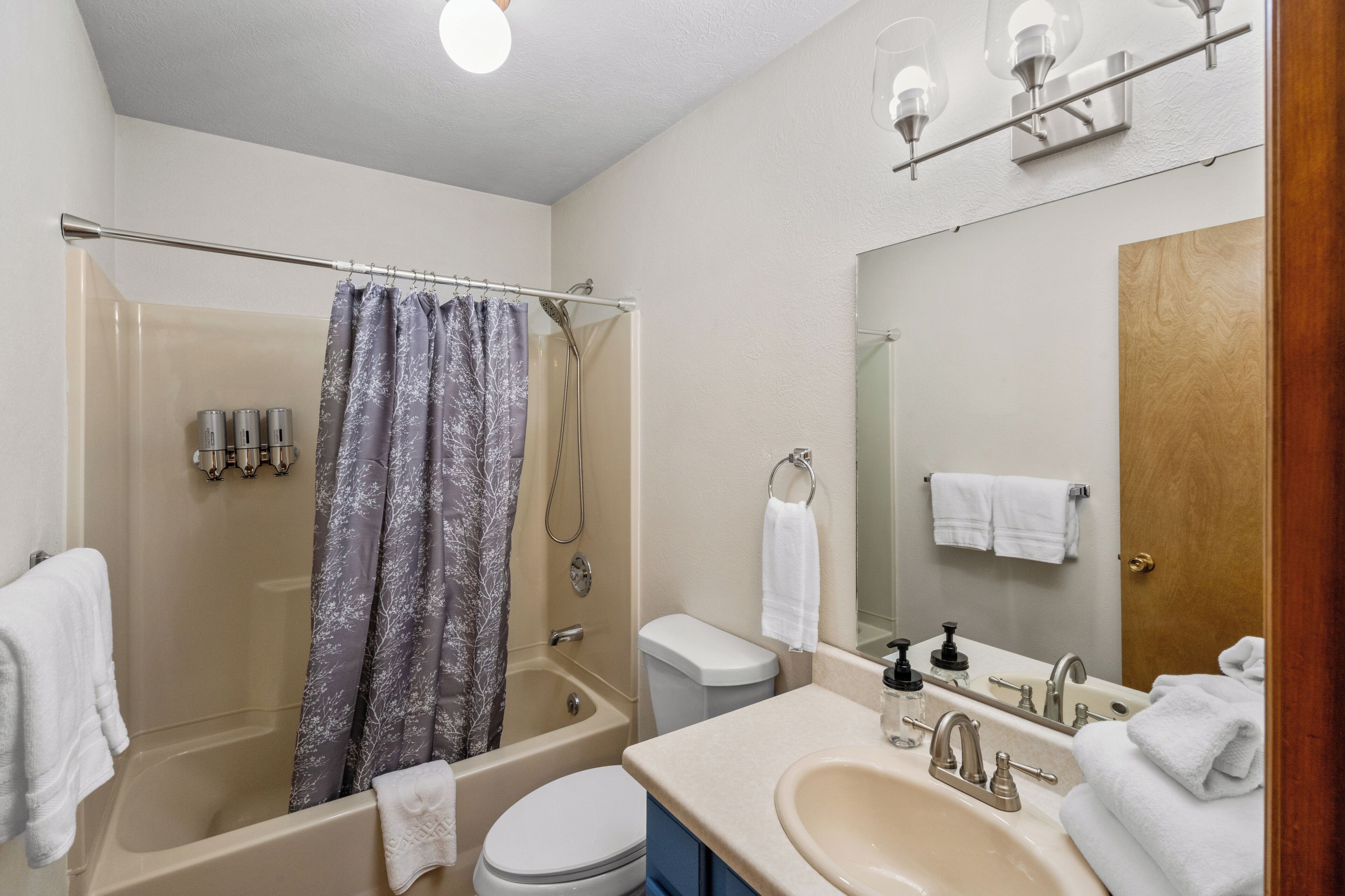 Une salle de bain équipée d’une baignoire, de toilettes, d’un lavabo et d’un rideau de douche.