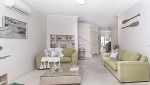 A spacious living room with a sofa, a coffee table, and a bookshelf. - `Beach Side` Warrnambool CBD (Warrnambool)